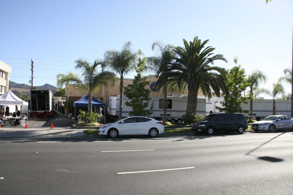 a parking lot with cars and palm trees