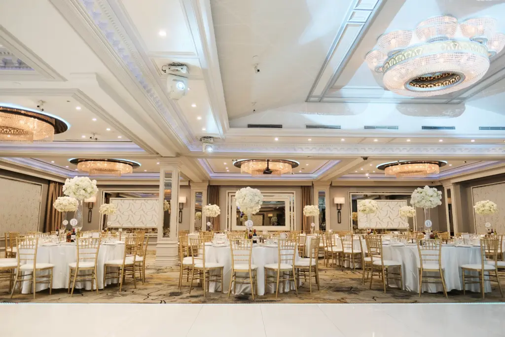 Glenoaks Ballroom reception with round tables, white florals and gold chiavari chairs