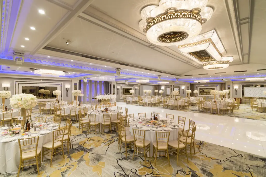 Glenoaks Ballroom dance floor bordered by round tables with tall white floral centerpieces