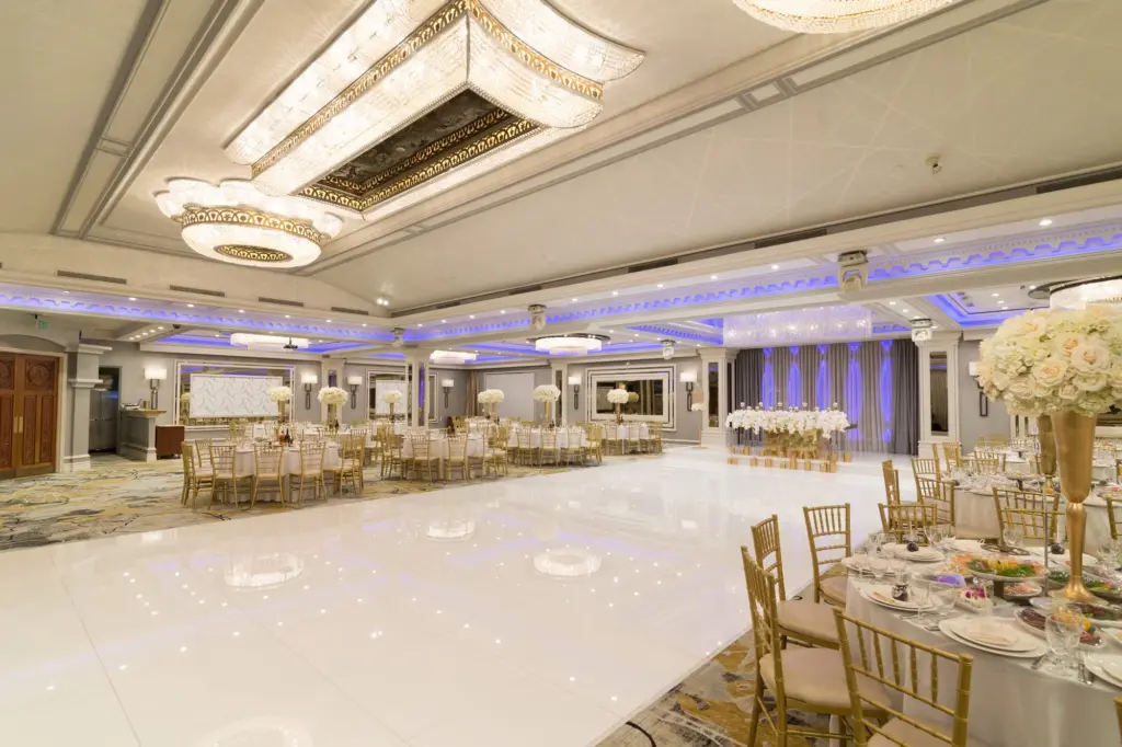 Round table with a floral centerpiece in the foreground of the Glenoaks Ballroom