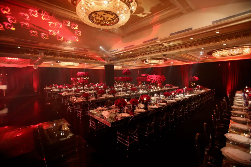 Glenoaks Ballroom decorated in red for a formal dinner with a long banquet table and rose centerpieces
