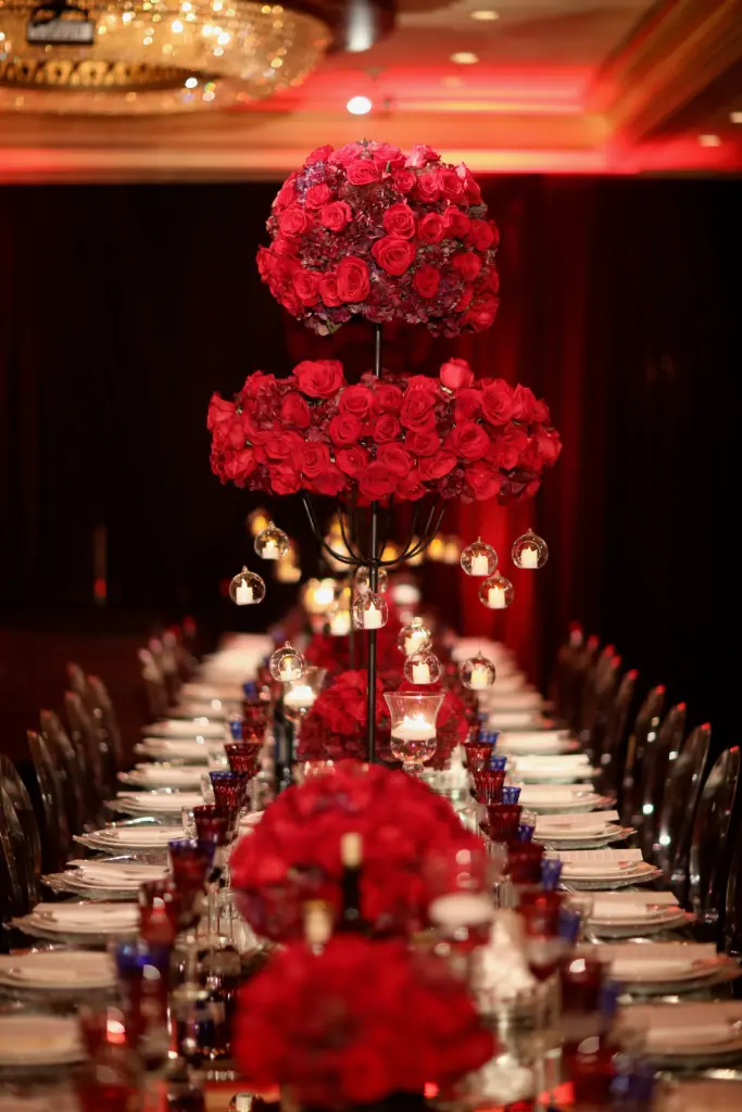 Tall red rose centerpiece with hanging candle globes above a Glenoaks Ballroom dinner table