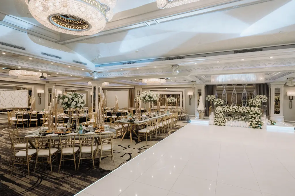 Glenoaks Ballroom reception with white blossom trees, gold chairs and a sweetheart table stage