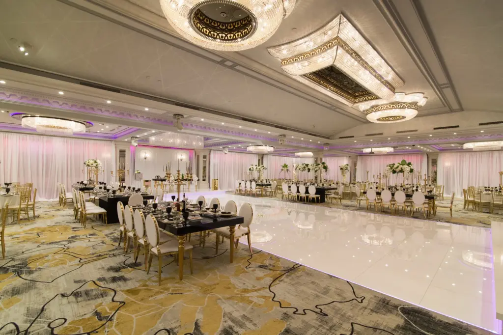 Tall white ostrich feather centerpiece over a black-linen table set for dinner