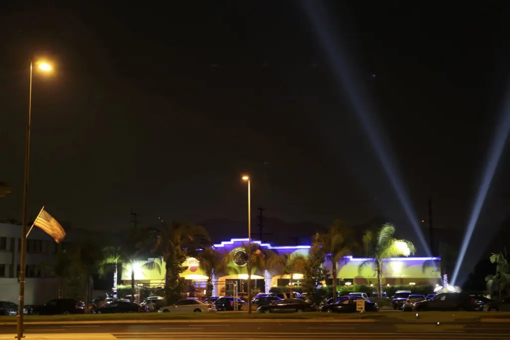 Night view of Glenoaks Ballroom exterior with spotlight beams over the parking lot