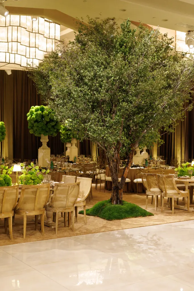 Live tree centerpiece on a grass mound surrounded by dining tables at The Landmark