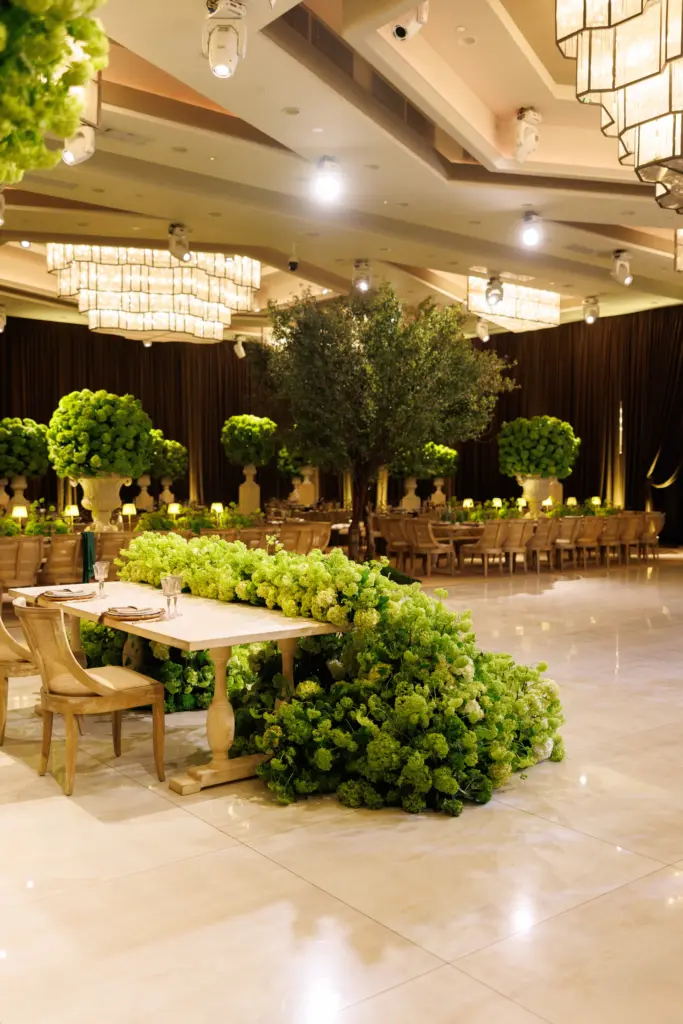 Floral table runner spilling onto the floor beside long banquet tables at The Landmark
