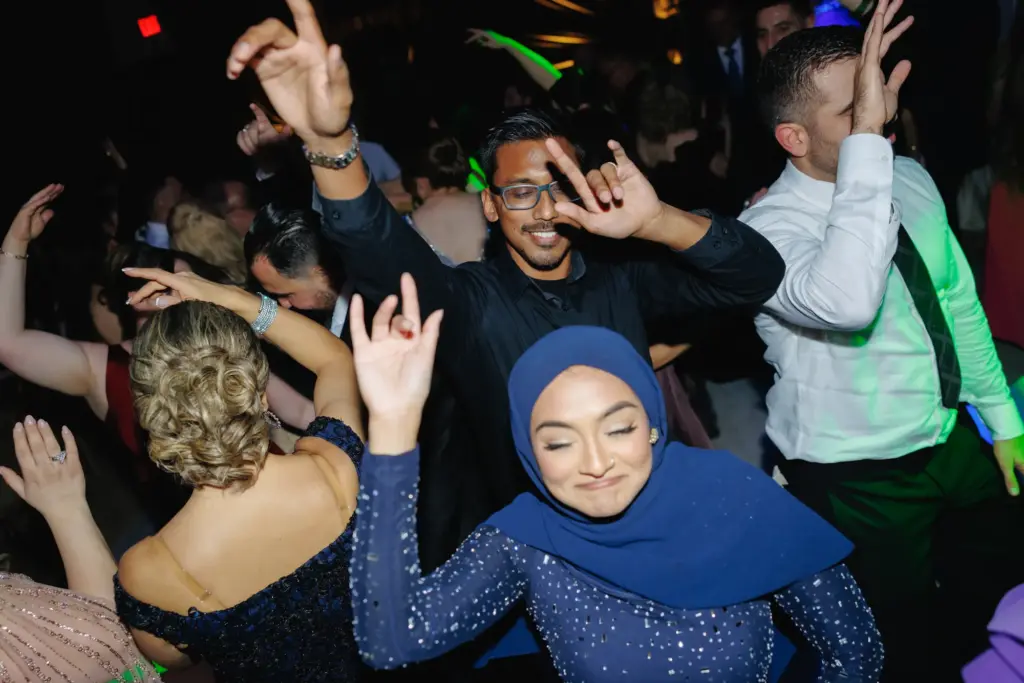 Guests lifting the bride and groom on chairs during a joyful reception dance