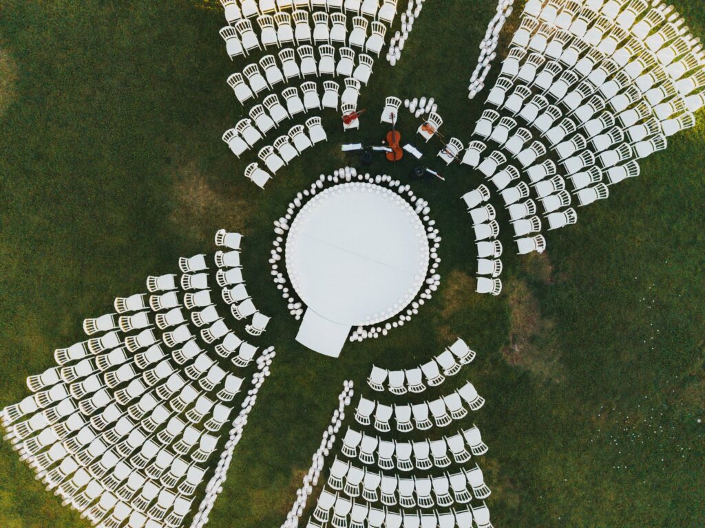 Aerial night view of an outdoor wedding ceremony at The Landmark with guests seated in a flower-shaped arrangement