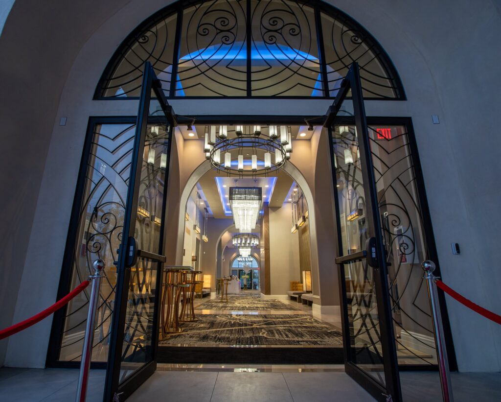 Arched lobby corridor with a patterned rug and blue accent lighting at The Landmark