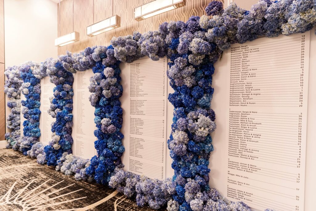Blue and purple hydrangea wall displaying the wedding seating chart at The Landmark