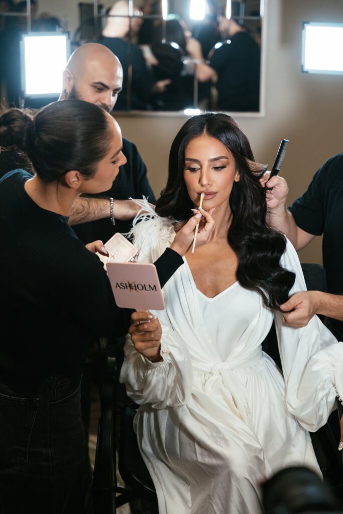 Bride having her hair and makeup done backstage before the wedding