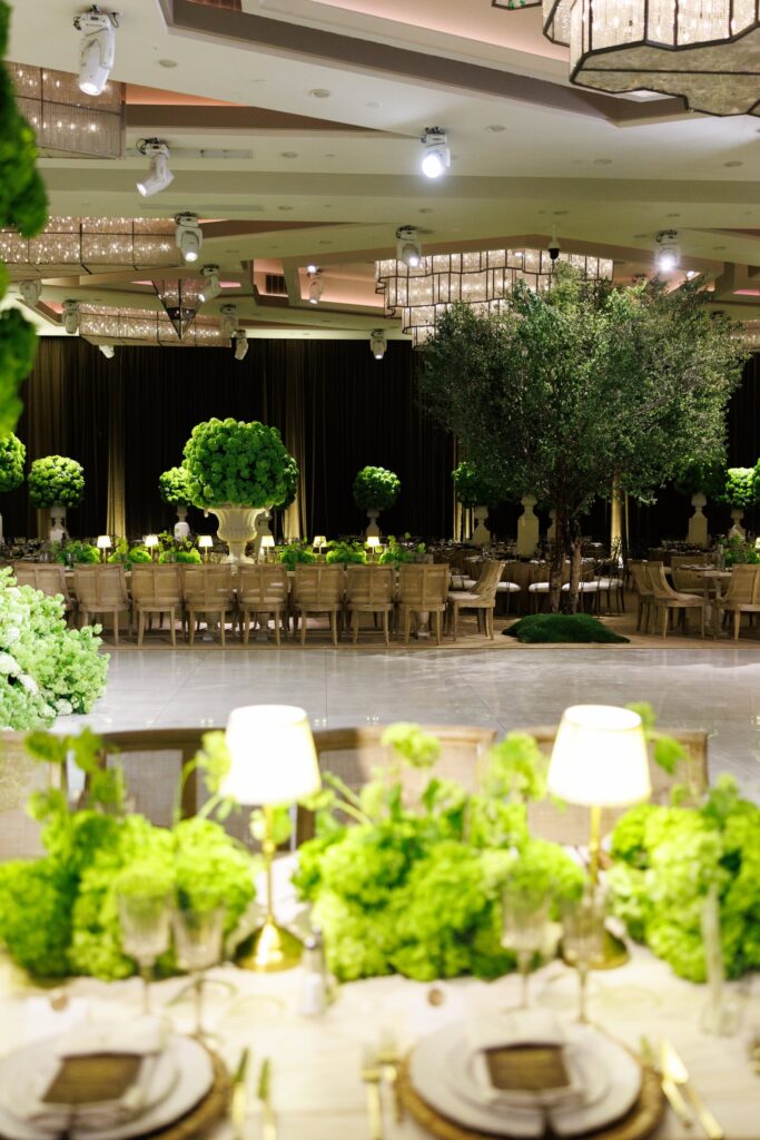 Ballroom reception with green topiary centerpieces and indoor trees