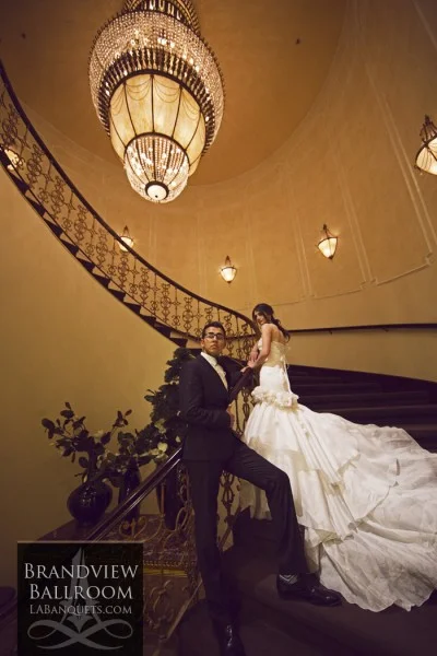 Bride and groom on the spiral staircase beneath a crystal chandelier at Brandview Ballroom