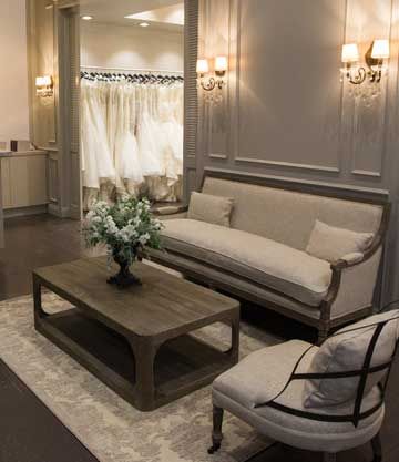 Bridal boutique lounge area with a sofa, coffee table, and floral arrangement