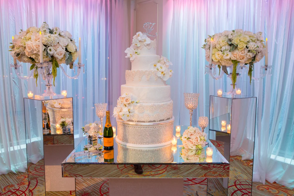 Wedding cake and champagne display on a mirrored dessert table