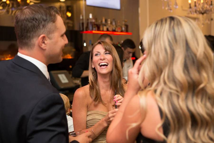 Guests laughing together during a cocktail hour at the bar