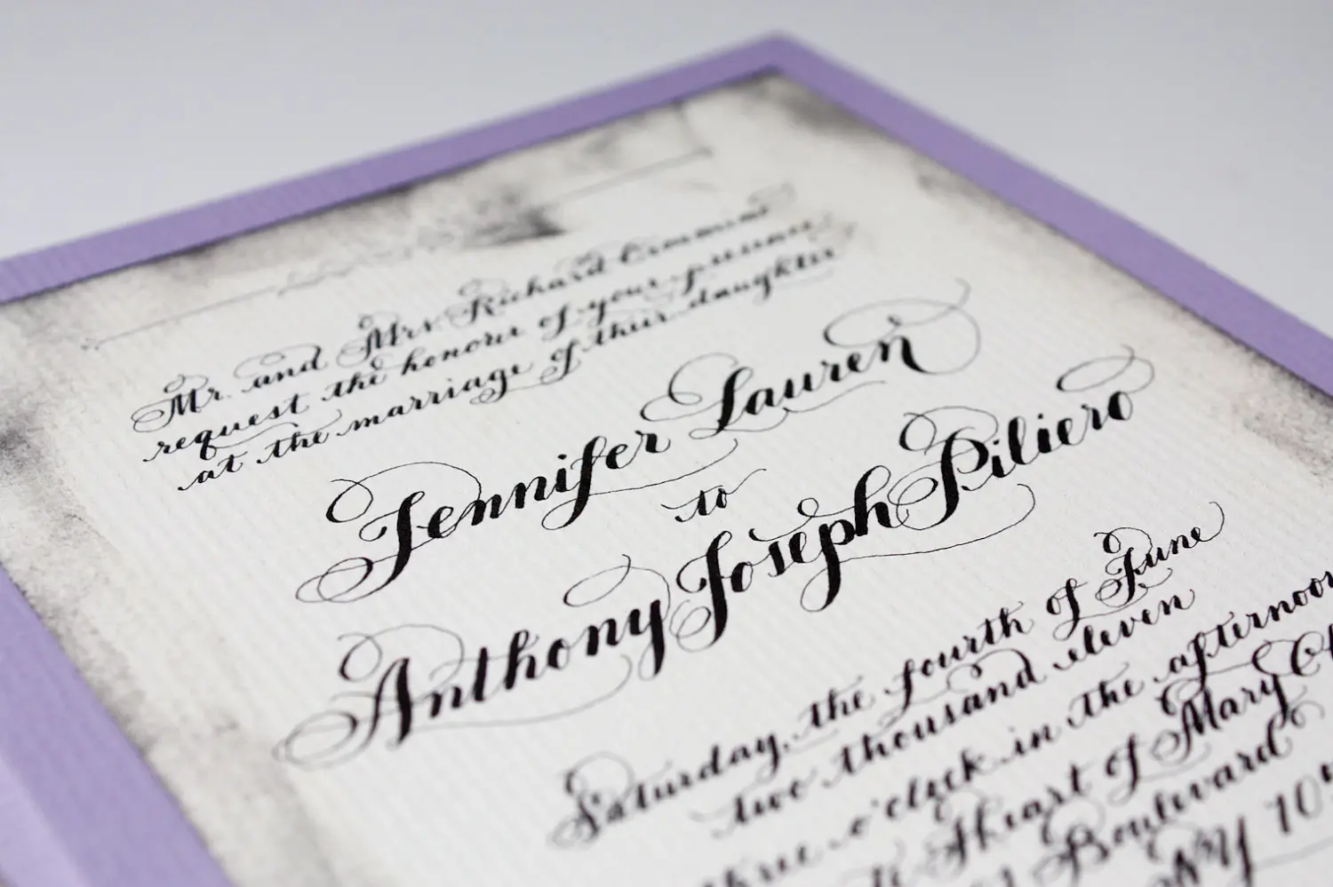 Elegant calligraphy wedding invitation with a lavender border