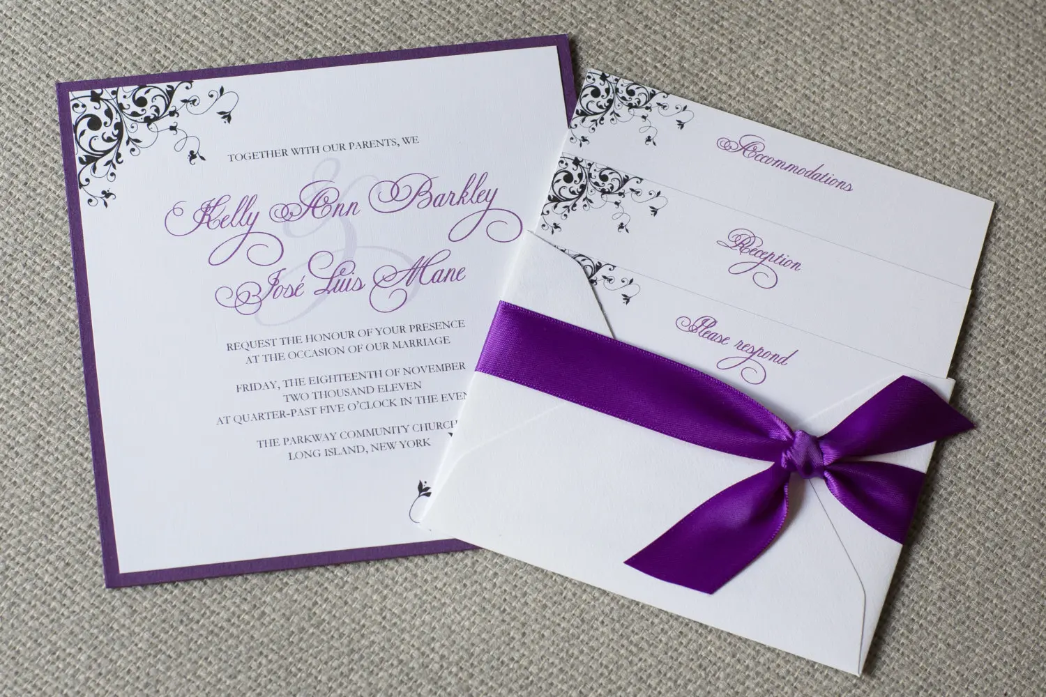 Purple-bordered wedding invitation suite tied with a satin ribbon