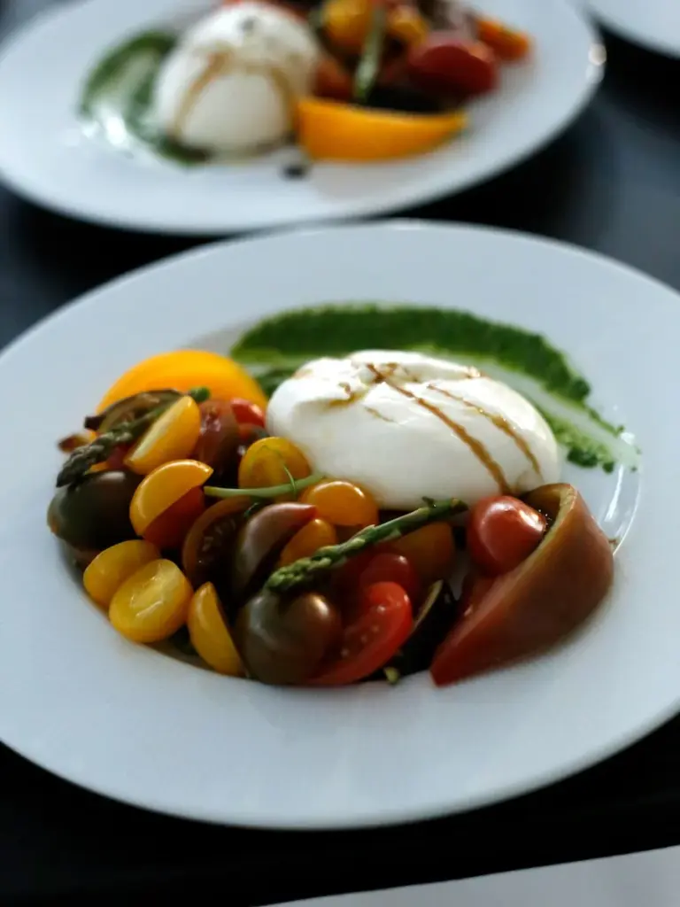 Burrata salad plate with heirloom tomatoes, asparagus, and pesto