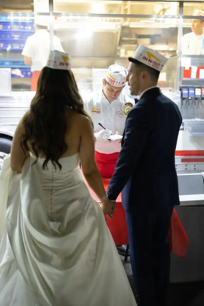 Bride and groom holding hands at an In-N-Out Burger counter during their wedding
