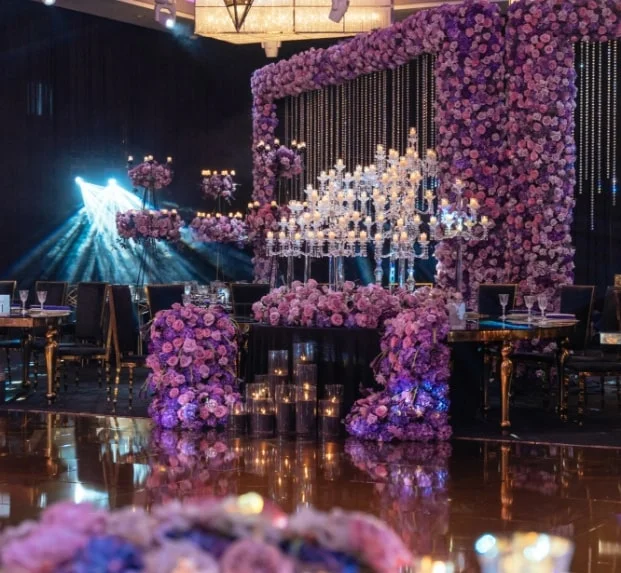 Purple and lavender floral wall installation with crystal candelabra chandeliers on the dance floor