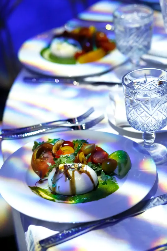 Burrata salad plate with heirloom tomatoes at a table set for a corporate gala dinner