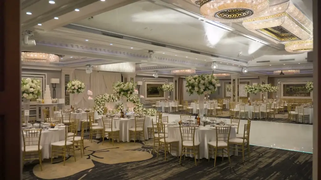 Glenoaks Ballroom reception set with round tables, floral centerpieces, and crystal chandeliers