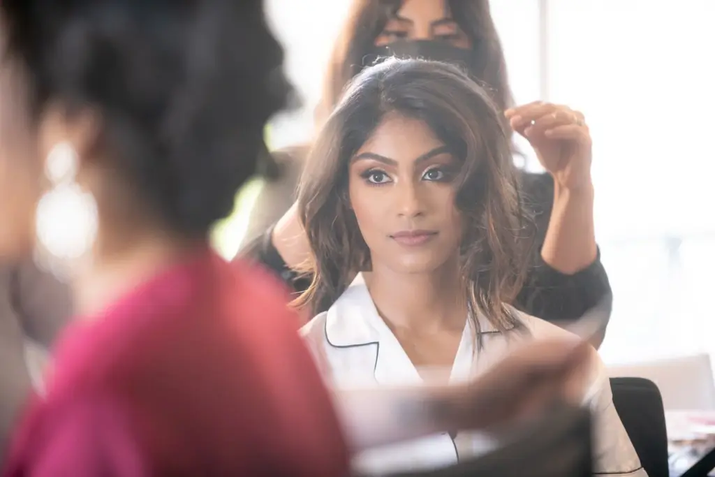 Bride having her hair styled by an attendant before the ceremony
