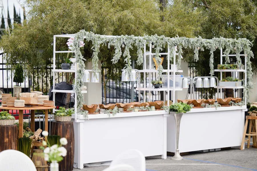 Outdoor catering buffet station with greenery garland and wooden serving bowls