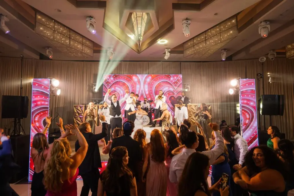 Wedding reception dance floor with a live band performing as guests dance
