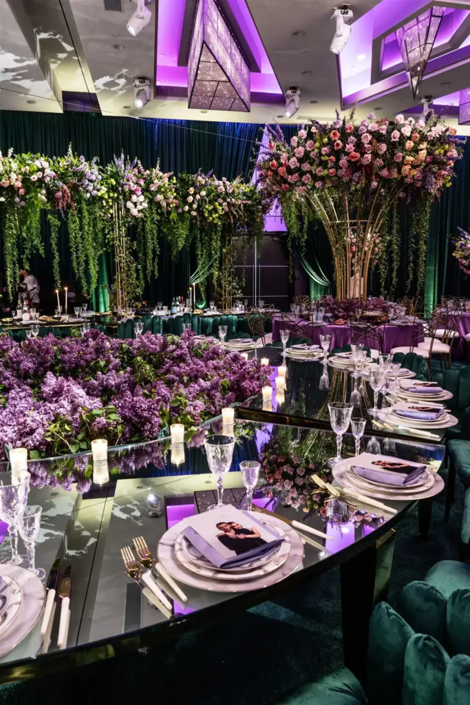 Wedding reception decorated with cascading floral chandeliers and purple lighting