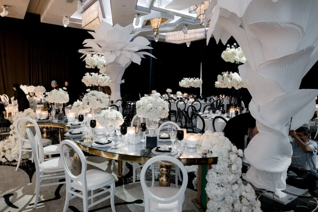 Black-and-white themed reception with a large paper flower art installation over guest tables