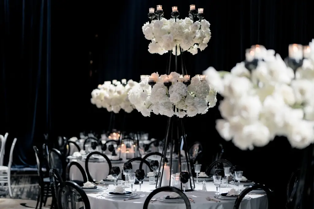 Tall black candelabra centerpiece with white hydrangeas on a round banquet table