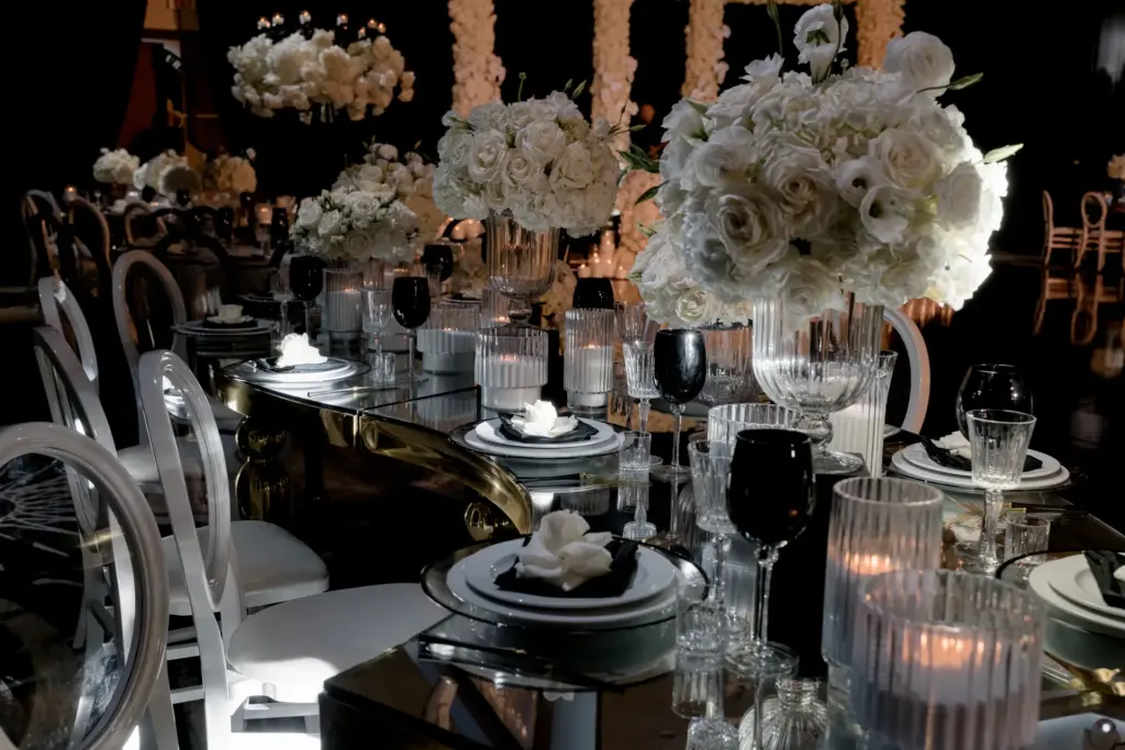 Gold-trimmed mirrored table set with white floral centerpieces and candlelight